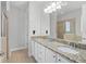 Bathroom featuring a double sink vanity with granite countertops and a walk-in shower at 7659 Wilmington Loop, Kissimmee, FL 34747