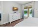 Bright bedroom featuring a white dresser, TV, and sliding glass door to the pool area at 7659 Wilmington Loop, Kissimmee, FL 34747