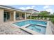 Enjoy the covered patio and poolside lounging around this pool and spa with brick pavers at 7659 Wilmington Loop, Kissimmee, FL 34747