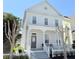 Inviting two-story home featuring a covered front porch, white picket fence, and manicured greenery at 802 Rosa St, Celebration, FL 34747