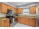 Close-up of the kitchen featuring wooden cabinets, stainless steel appliances and light countertops at 825 Agnes Dr, Altamonte Springs, FL 32701