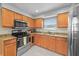 Close-up of the kitchen featuring wooden cabinets, stainless steel appliances and light countertops at 825 Agnes Dr, Altamonte Springs, FL 32701