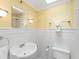 Bathroom with white tile, pedestal sink, and bright lighting; a clean and classic design at 871 Cynthianna Cir, Altamonte Springs, FL 32701