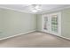 An empty bedroom with double doors leading to the outside and neutral carpeting at 871 Cynthianna Cir, Altamonte Springs, FL 32701