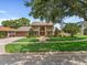 Sprawling front lawn and a two-story home with twin balconies and a brick-paved driveway leading to an attached garage at 871 Cynthianna Cir, Altamonte Springs, FL 32701