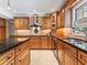 This kitchen features dark granite countertops, a stainless steel sink, tile backsplash and custom wood cabinets at 871 Cynthianna Cir, Altamonte Springs, FL 32701