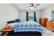 Bright bedroom with a ceiling fan, dresser, and a blue patterned quilt on the bed at 101 Ludlow Dr, Longwood, FL 32779