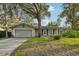 Charming single-story home with mature trees, well-kept lawn, and a two-car garage on a sunny day at 101 Ludlow Dr, Longwood, FL 32779