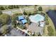 Aerial view of community pool, playground and clubhouse near a scenic pond and well maintained roadways at 102 Spanish Moss Ct, Orlando, FL 32828