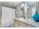 Cozy bathroom featuring a vanity with granite counters, decorative mirror, and a shower-tub combo at 102 Spanish Moss Ct, Orlando, FL 32828