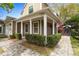 Charming front porch with brick paver walkway, lush green bushes and white support columns on a sunny day at 102 Spanish Moss Ct, Orlando, FL 32828