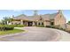 Exterior of the clubhouse with stone and tile roof, porte-cochere and lush landscaping at 10236 Beechwood Ln, Orlando, FL 32832