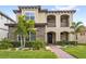 Charming two-story home features a stone facade, stucco accents, and a manicured lawn with tropical landscaping at 10236 Beechwood Ln, Orlando, FL 32832
