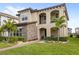 Inviting two-story house boasts stone accents, landscaped gardens, and a welcoming entrance at 10236 Beechwood Ln, Orlando, FL 32832