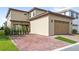 Exterior shot of the home featuring a two-car garage and brick-paved driveway at 10236 Beechwood Ln, Orlando, FL 32832