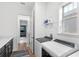 Well-lit laundry room with modern washer and dryer, shelving, and a view into the bedroom at 10236 Beechwood Ln, Orlando, FL 32832