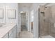 Modern bathroom with a quartz countertop vanity, tiled shower, and access to a walk-in closet at 10274 Hadley St, Orlando, FL 32829