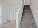 Elegant staircase with plush gray carpeting and white railings, leading to upper level of home at 10274 Hadley St, Orlando, FL 32829