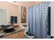 Bathroom featuring granite counters, bowl sink, and a blue patterned shower curtain at 10290 Cypress Vine Dr, Orlando, FL 32827