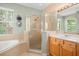 Bright bathroom with a glass-enclosed shower, large vanity, and window for natural light at 10290 Cypress Vine Dr, Orlando, FL 32827