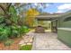 Backyard featuring an outdoor kitchen with stone accents and a beautiful paver patio surrounded by tropical foliage at 10290 Cypress Vine Dr, Orlando, FL 32827