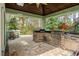 Outdoor kitchen featuring built in grill, stone accents, and a covered patio at 10290 Cypress Vine Dr, Orlando, FL 32827