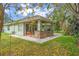 Backyard with patio, outdoor kitchen, mature trees and lush green yard at 10290 Cypress Vine Dr, Orlando, FL 32827