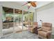 Relaxing sunroom with a view of outdoor grill and kitchen area, tile floor, ceiling fan, and comfortable chairs at 10290 Cypress Vine Dr, Orlando, FL 32827