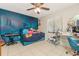 Cozy bedroom with bright blue accent wall, tiled floors, and ceiling fan at 12240 Huntsman Ln, Orlando, FL 32826