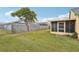 Private backyard featuring a wood fence, lush green grass, and a screened-in patio at 13469 Texas Woods Cir, Orlando, FL 32824