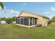 Exterior view of enclosed patio with screen windows in landscaped backyard at 13469 Texas Woods Cir, Orlando, FL 32824