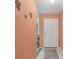 Hallway with peach-colored walls leading to a white door, with neutral tile flooring at 13469 Texas Woods Cir, Orlando, FL 32824