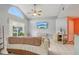 Cozy living room featuring tile floors, large arched window, and ceiling fan at 13469 Texas Woods Cir, Orlando, FL 32824