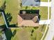 Aerial view of a well-maintained house with a brown roof, green lawn, and landscaped surroundings at 1727 Garden View St, Mascotte, FL 34753