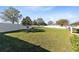 Expansive backyard featuring lush green grass, mature trees, and a white privacy fence at 1727 Garden View St, Mascotte, FL 34753