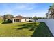 Expansive backyard with a well-maintained lawn, partial privacy fence, and the rear exterior of the home at 1727 Garden View St, Mascotte, FL 34753