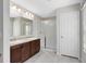 Bright bathroom featuring a double sink vanity with a white stone countertop and a glass-enclosed shower at 1727 Garden View St, Mascotte, FL 34753