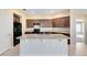 Kitchen with an island, dark wood cabinets, and neutral-colored countertops at 1727 Garden View St, Mascotte, FL 34753