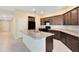 Spacious kitchen with an island, dark cabinets, and a neutral countertop at 1727 Garden View St, Mascotte, FL 34753