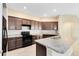 Modern kitchen with dark wood cabinets, an island, and stainless steel appliances at 1727 Garden View St, Mascotte, FL 34753