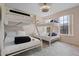 Bright bedroom featuring two sets of white bunk beds, two windows for natural light, and a modern ceiling fan at 176 Blue Jay Way, Davenport, FL 33896