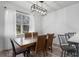 Dining area with a modern chandelier, wood table and chairs, and bright natural light at 176 Blue Jay Way, Davenport, FL 33896