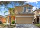 Two-story home featuring an attached two-car garage, well-maintained lawn and simple landscaping at 176 Blue Jay Way, Davenport, FL 33896