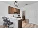 Kitchen and laundry room with quartz countertops, stainless steel appliances, breakfast bar, and wood floors at 176 Blue Jay Way, Davenport, FL 33896