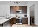 Modern kitchen with stainless steel appliances, quartz countertops, and nearby laundry room at 176 Blue Jay Way, Davenport, FL 33896