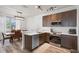 Modern kitchen open to the dining area features stainless appliances and granite countertops at 176 Blue Jay Way, Davenport, FL 33896