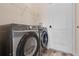 Practical laundry room with a modern Samsung washer and dryer set and wire shelving for organized storage at 176 Blue Jay Way, Davenport, FL 33896