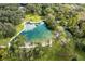 Aerial view of large, natural shaped pool surrounded by trees at 2166 Woodbridge Rd, Longwood, FL 32779