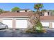 View of the townhouse garages showing the doors and surrounding landscape on a bright day at 2166 Woodbridge Rd, Longwood, FL 32779