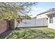 Fenced backyard showcasing a mix of brick and white privacy fences, accented by lush trees and garden at 2168 Continental St, St Cloud, FL 34769